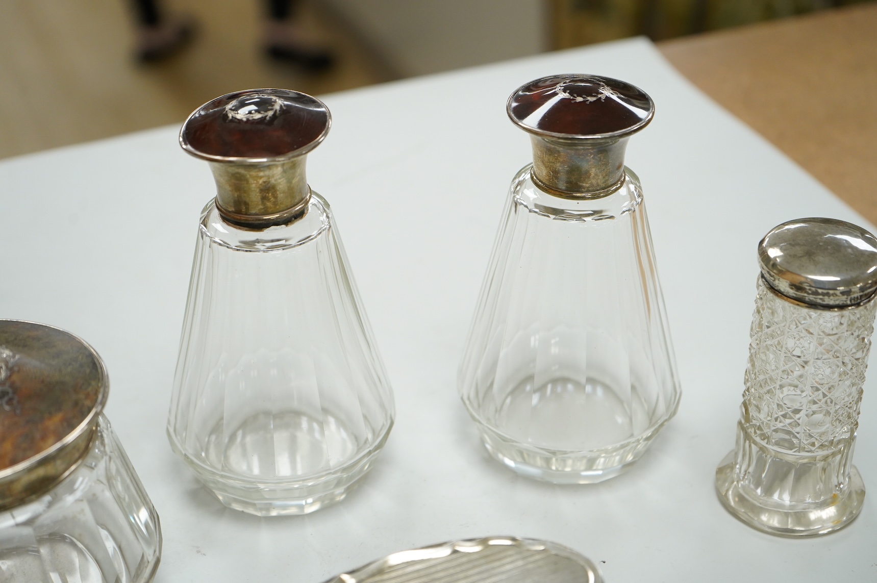 Three George V silver and tortoiseshell mounted glass toilet jars, Adie Brothers, Birmingham, 1925 & 1927, together with three other silver mounted glass toilet jars.